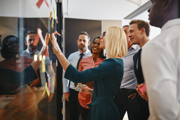 Young businesswoman and her team brainstorming with sticky notes