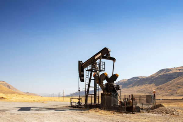 Oil drilling derricks at desert oilfield. Crude oil production f