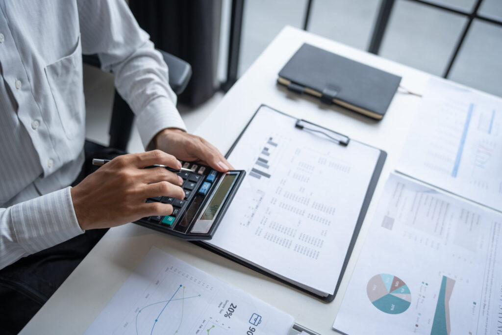 Businessman Calculating Finances with Calculator in Modern Office.