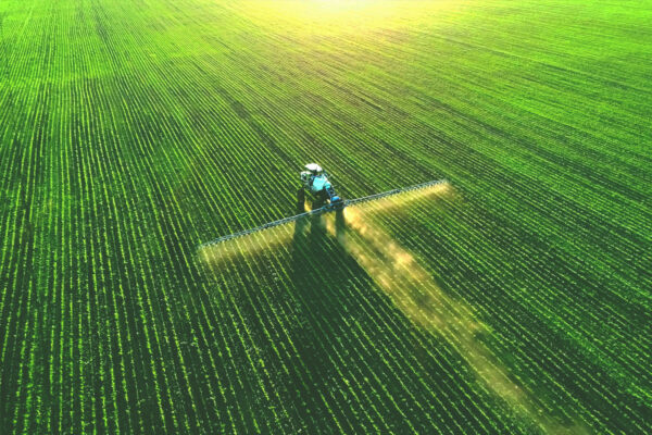 Tractor spray fertilizer on green field drone high angle view, a